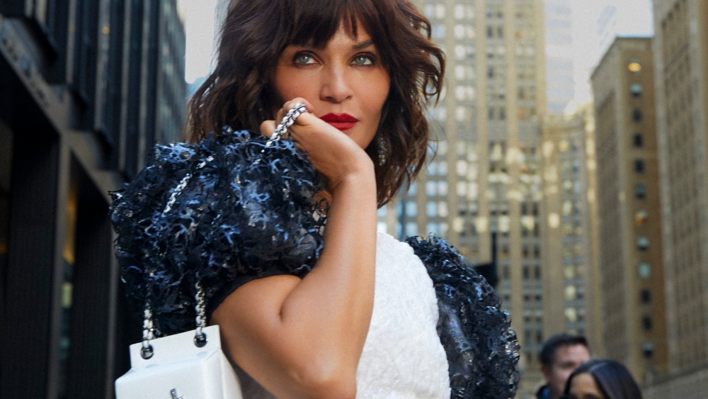 Helena Christensen for What Goes Around Comes Around's first ad campaign, wearing a black-and-white Chanel ensemble and carrying a milk Chanel bag.