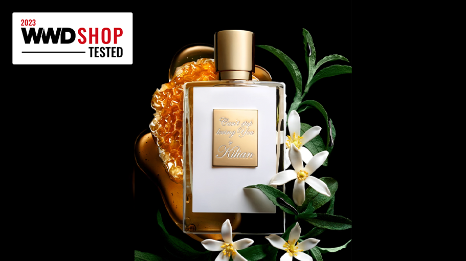 white perfume bottle set against orange blossom and honeycomb
